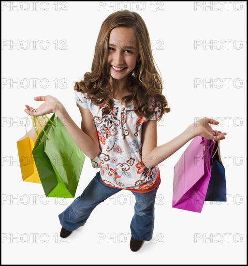 Young girl holding shopping bags. Photographe : Mike Kemp