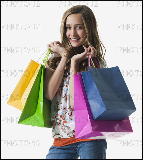 Young girl holding shopping bags. Photographe : Mike Kemp