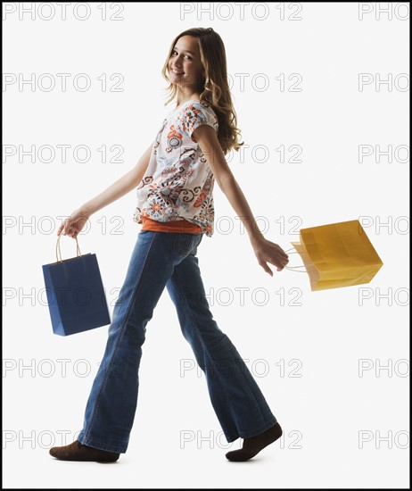 Young girl holding shopping bags. Photographe : Mike Kemp