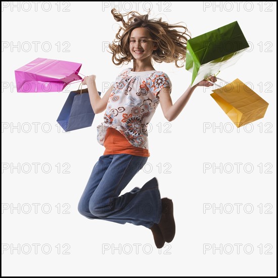 Young girl holding shopping bags. Photographe : Mike Kemp