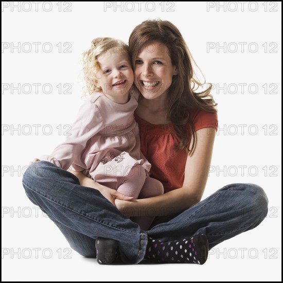 Mother holding daughter in her lap. Photographe : Mike Kemp