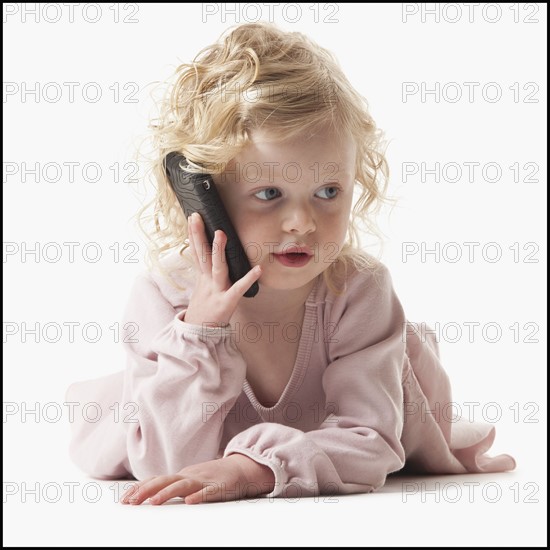 Young girl playing with a cellular phone. Photographe : Mike Kemp