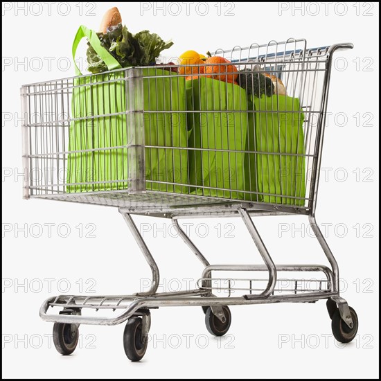 Grocery cart full of bagged produce. Photographe : Mike Kemp