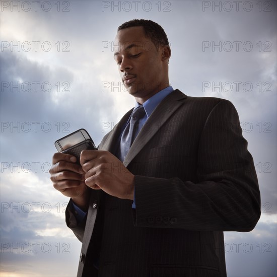 Businessman texting. Photographe : Mike Kemp