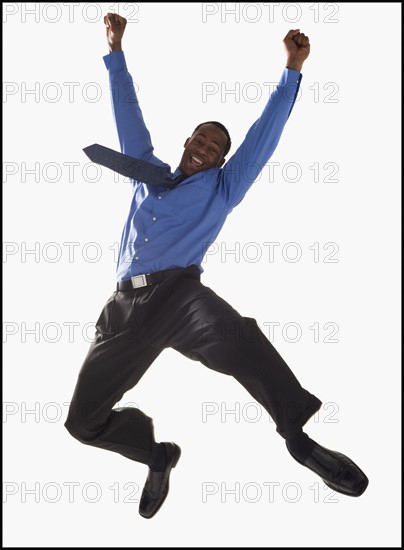 Excited businessman jumping. Photographe : Mike Kemp