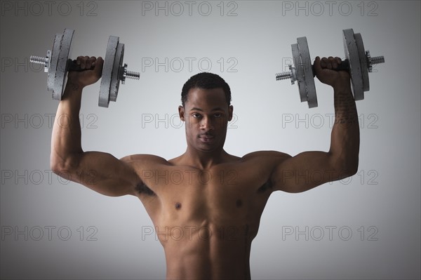 Muscular man lifting dumbbells. Photographe : Mike Kemp