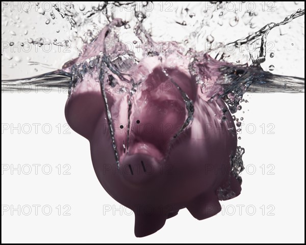 Piggy bank sinking in water. Photographe : Mike Kemp