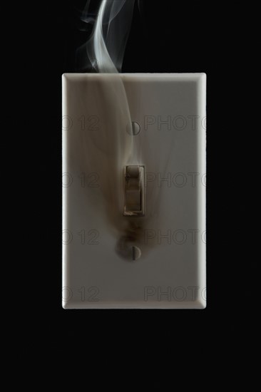 Smoke emanating from an electrical switch. Photographe : Mike Kemp