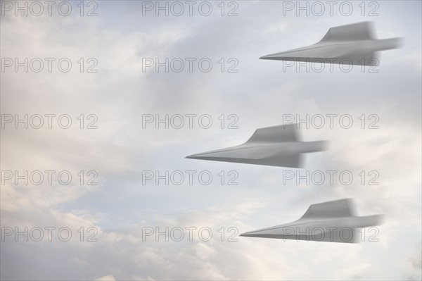 Three paper airplanes flying through the air. Photographe : Mike Kemp