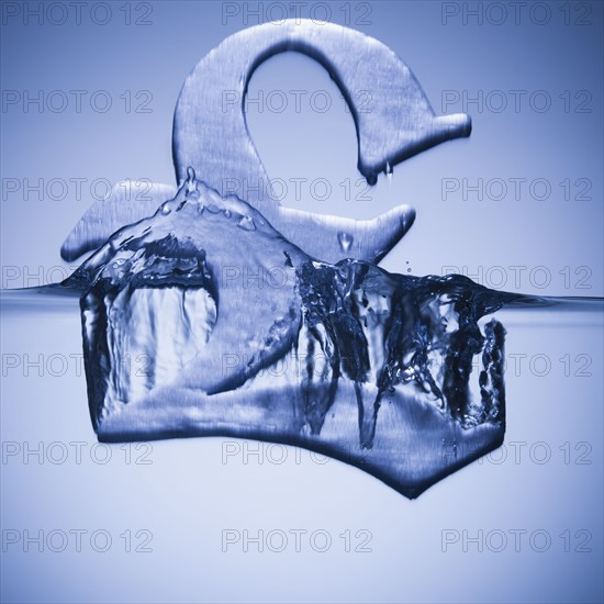 British pound symbol sinking in water. Photographe : Mike Kemp