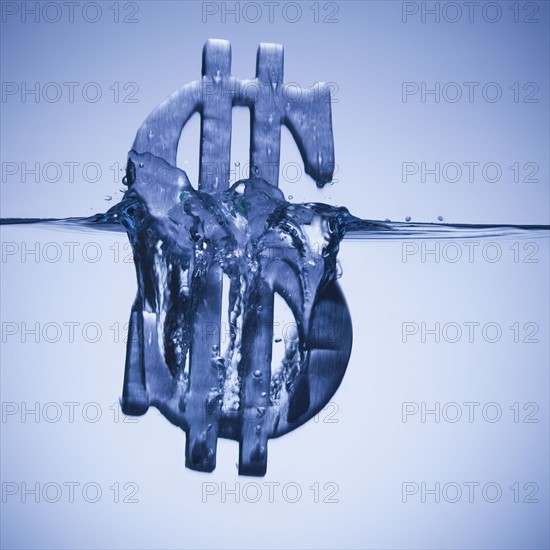 Dollar symbol sinking in water. Photographe : Mike Kemp