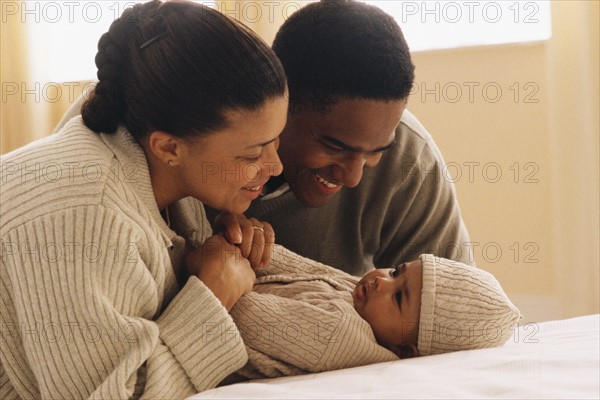 Mother and father admiring their baby. Photographe : Rob Lewine