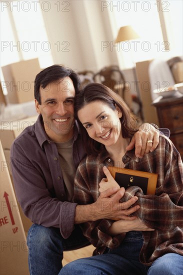 Young couple unpacking boxes in their new home. Photographe : Rob Lewine