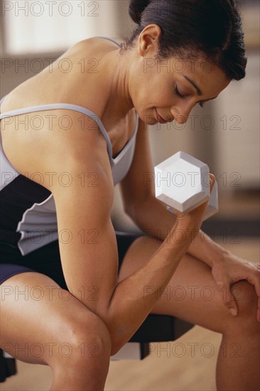 Woman exercising with dumbbells. Photographe : Rob Lewine