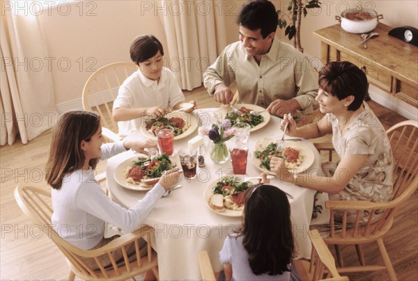 Family eating dinner together. Photographe : Rob Lewine