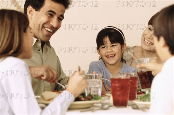 Family eating dinner together. Photographe : Rob Lewine