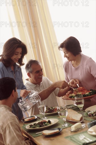 Family eating dinner together. Photographe : Rob Lewine