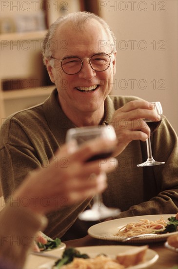 Toasting with wine at the dinner table. Photographe : Rob Lewine