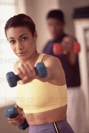 Woman exercising with dumbbells. Photographe : Rob Lewine