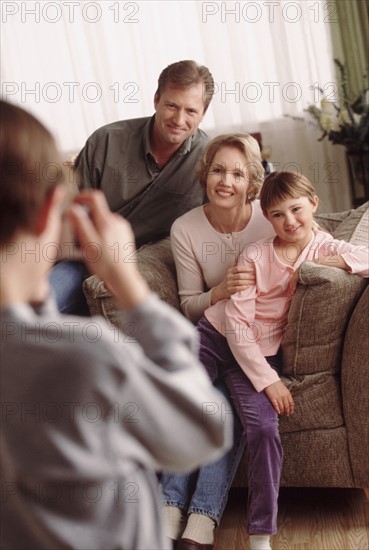 Young boy taking a family picture. Photographe : Rob Lewine