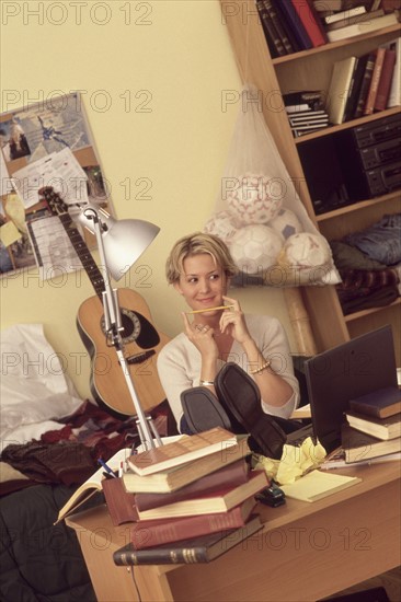 Young girl relaxing at her desk. Photographe : Rob Lewine