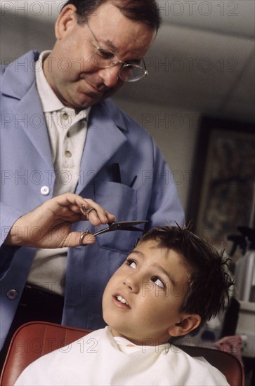 Young boy getting a haircut. Photographe : Rob Lewine