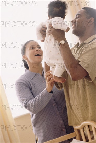 Father picking up his baby. Photographe : Rob Lewine