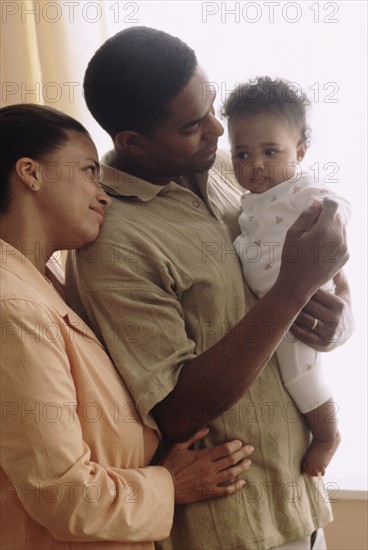 Father and mother with their baby. Photographe : Rob Lewine