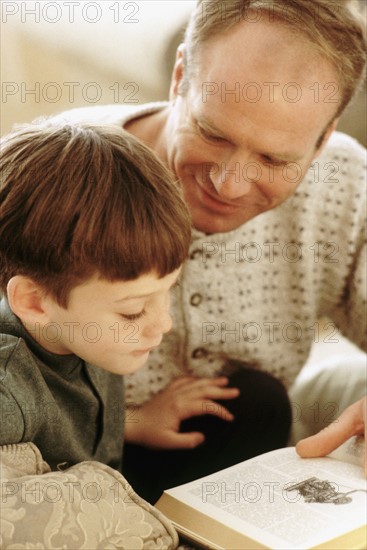 Father and son reading together. Photographe : Rob Lewine