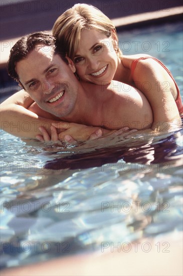 Couple embracing in pool. Photographe : Rob Lewine