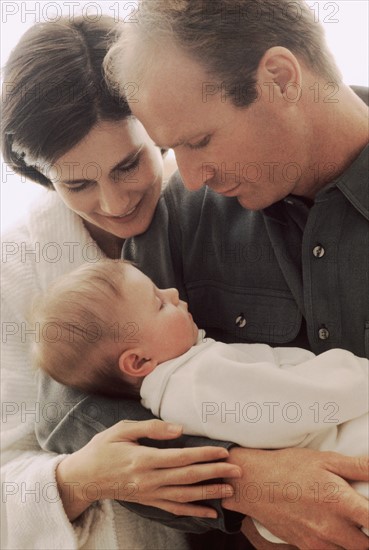 Mother and father admiring their newborn baby. Photographe : Rob Lewine