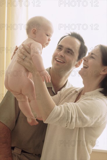 Mother and father admiring their newborn baby. Photographe : Rob Lewine
