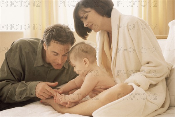 Mother and father admiring their newborn baby. Photographe : Rob Lewine