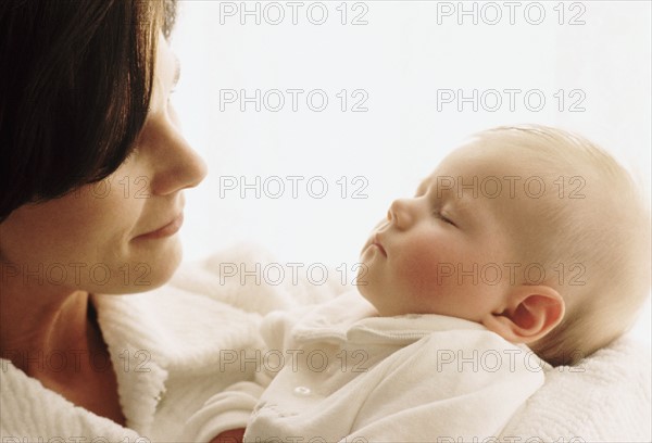 Mother holding her sleeping baby. Photographe : Rob Lewine