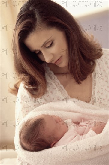 Mother holding her newborn baby. Photographe : Rob Lewine