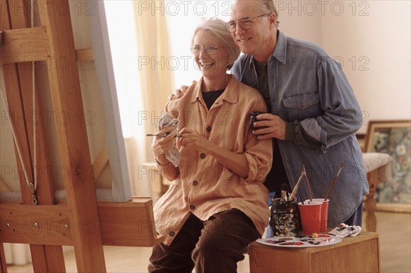 Couple admiring woman's painting. Photographe : Rob Lewine