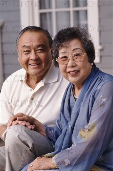 Portrait of a couple in front of their house. Photographe : Rob Lewine