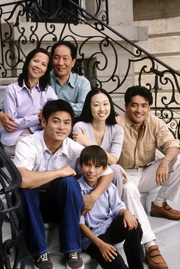 Portrait of a family on the front steps of their house. Photographe : Rob Lewine