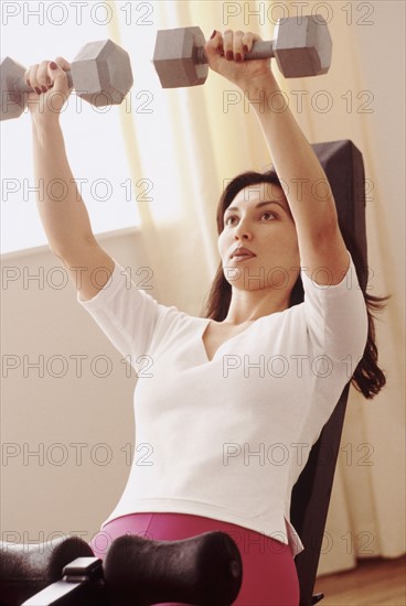 Woman lifting weights. Photographe : Rob Lewine