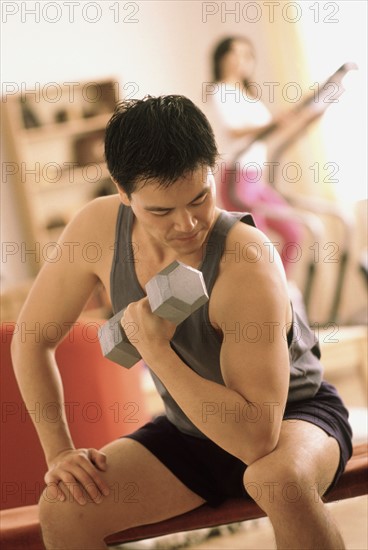 Man exercising with a dumbbell. Photographe : Rob Lewine