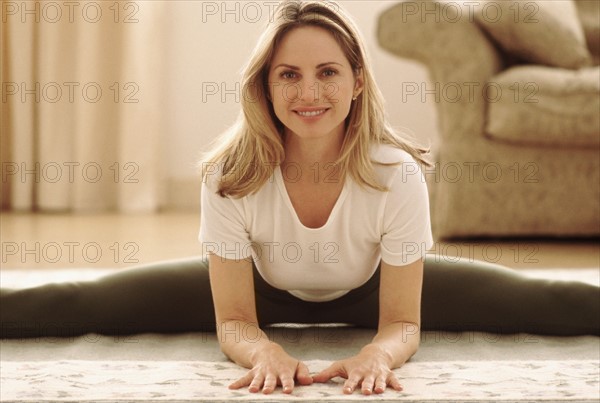 Woman stretching on the floor. Photographe : Rob Lewine