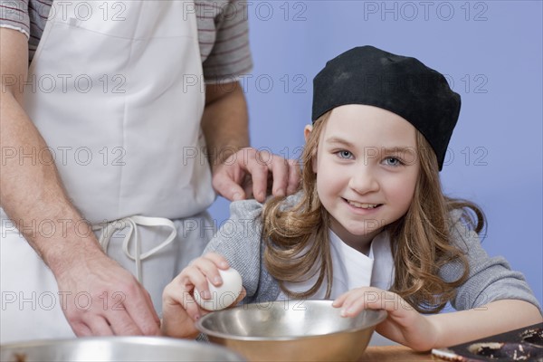 Young girl cracking an egg. Photographe : Dan Bannister