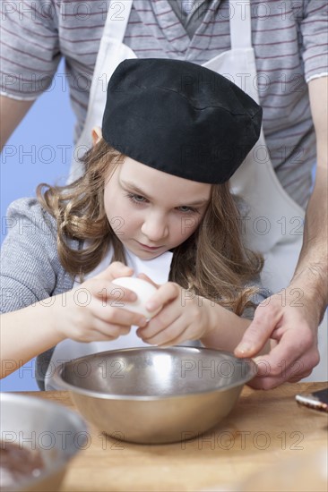 Young girl cracking an egg. Photographe : Dan Bannister