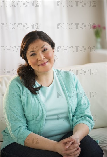 Overweight woman sitting on couch.