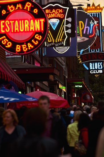 Crowd of people and Illuminated signs on Beale Street.