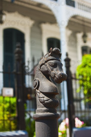 Iron statue of a horse's head on top of a post.