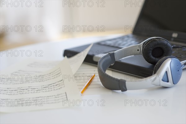Sheet music headphones and laptop.