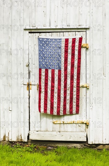 American flag draped on door of barn.