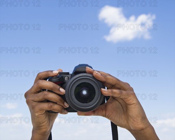 Hands holding a digital camera.