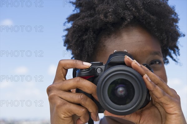 Woman taking picture with a digital camera.